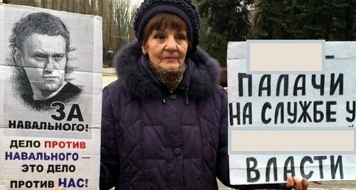 Галина Тихенко держит плакаты с требованием расследовать покушение на Навального. Название силового ведомства и характеристика власти на одном из ее плакатов заретушированы "Каказским узлом" в соответствии с российским законодательством. Волгоград, 27 декабря 2020 года. Фото Татьяны Филимоновой для "Кавказского узла".